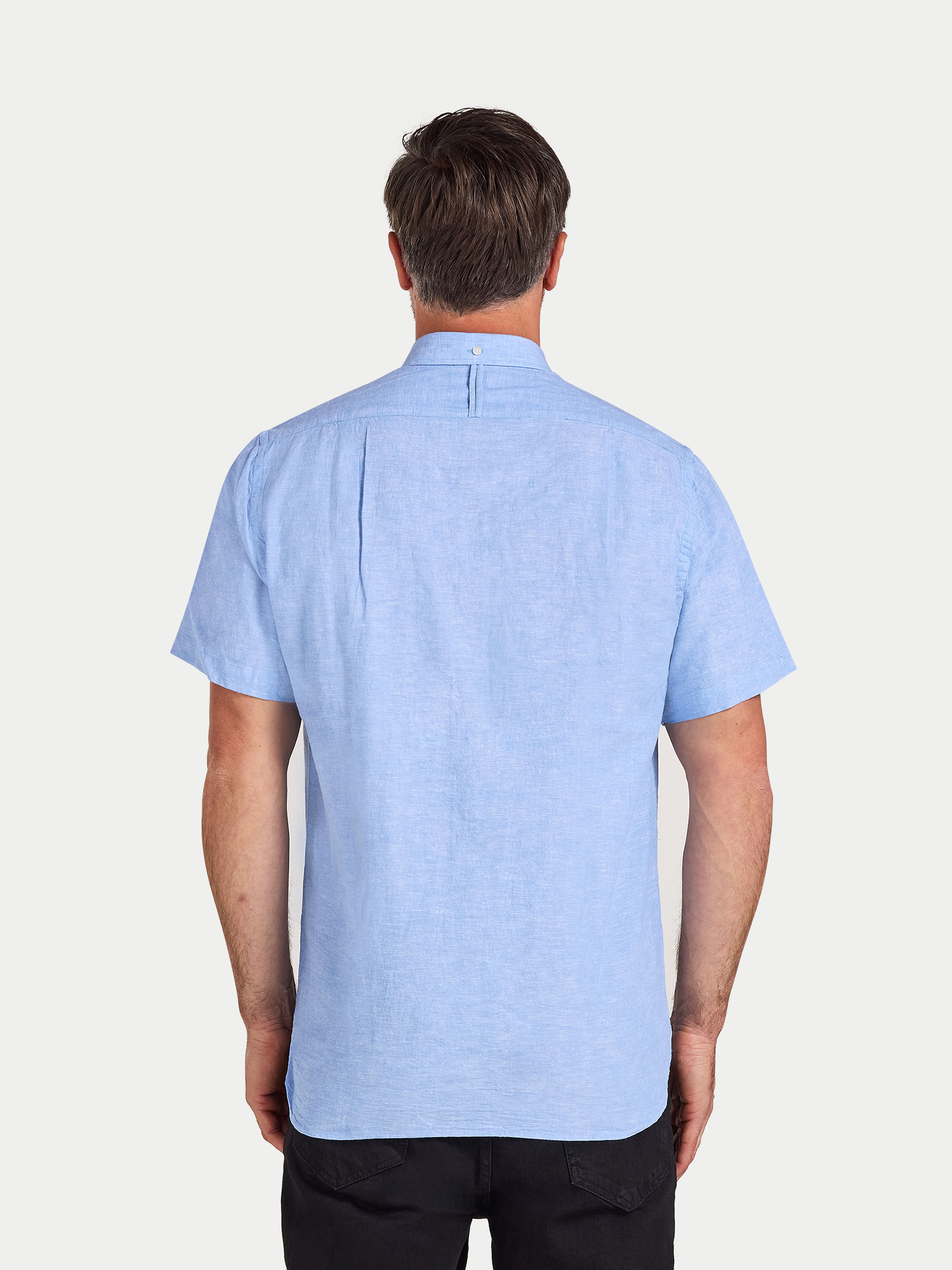 Man wearing a light blue short-sleeve shirt on a white background