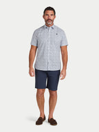 Man wearing Raging Bull Floral Cotton Poplin Short Sleeve Shirt in Sky Blue and Classic Chino Short in navy, available in sizes S-6XL.