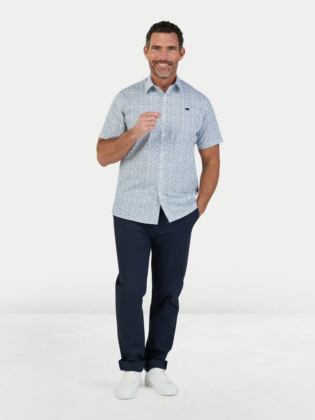 Man wearing Raging Bull Floral Cotton Poplin Short Sleeve Shirt in Sky Blue and Classic Chino Trousers in navy, available in sizes S-6XL.