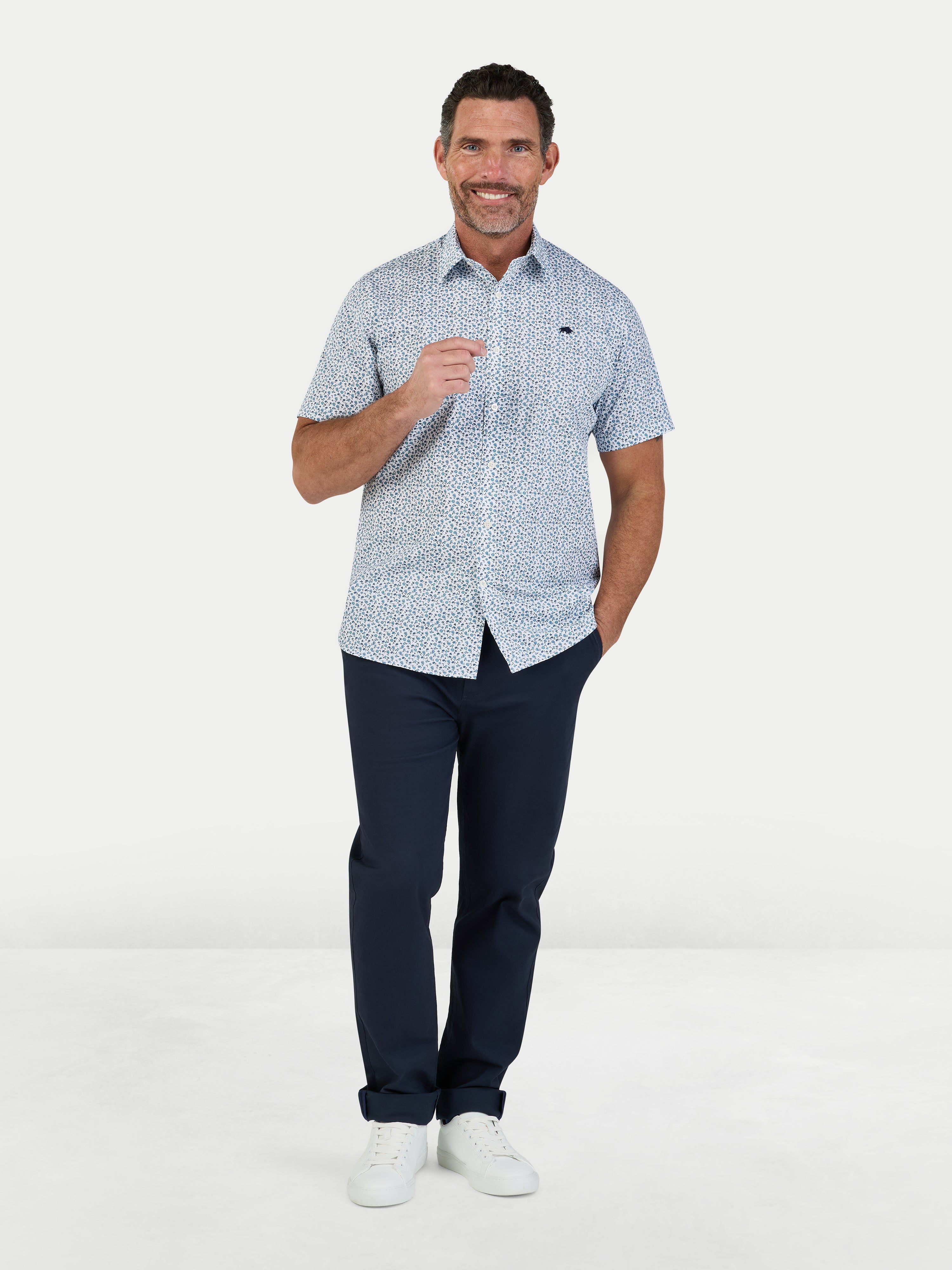 Man wearing Raging Bull Floral Cotton Poplin Short Sleeve Shirt in Sky Blue and Classic Chino Trousers in navy, available in sizes S-6XL.
