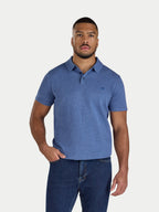 Man wearing a blue polo shirt and jeans on a white background