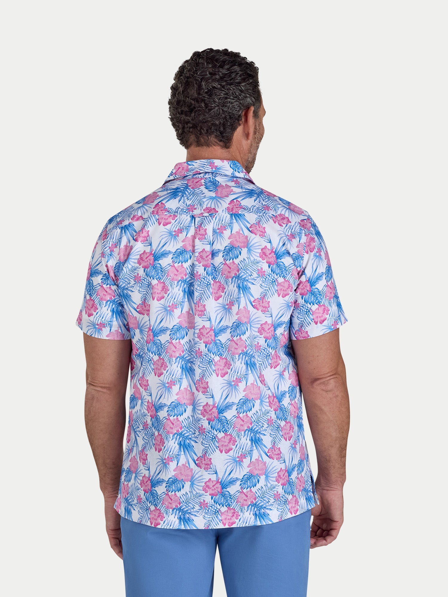 Man wearing a colorful floral shirt with a white background