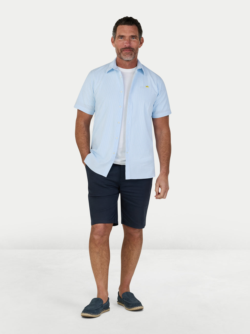 Man wearing Raging Bull Orleans Seersucker Stripe Short Sleeve Shirt in Sky Blue and Classic Chino Shorts in Navy, available in sizes S-6XL.