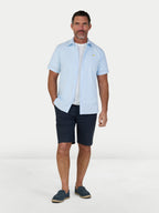 Man wearing Raging Bull Orleans Seersucker Stripe Short Sleeve Shirt in Sky Blue and Classic Chino Shorts in Navy, available in sizes S-6XL.