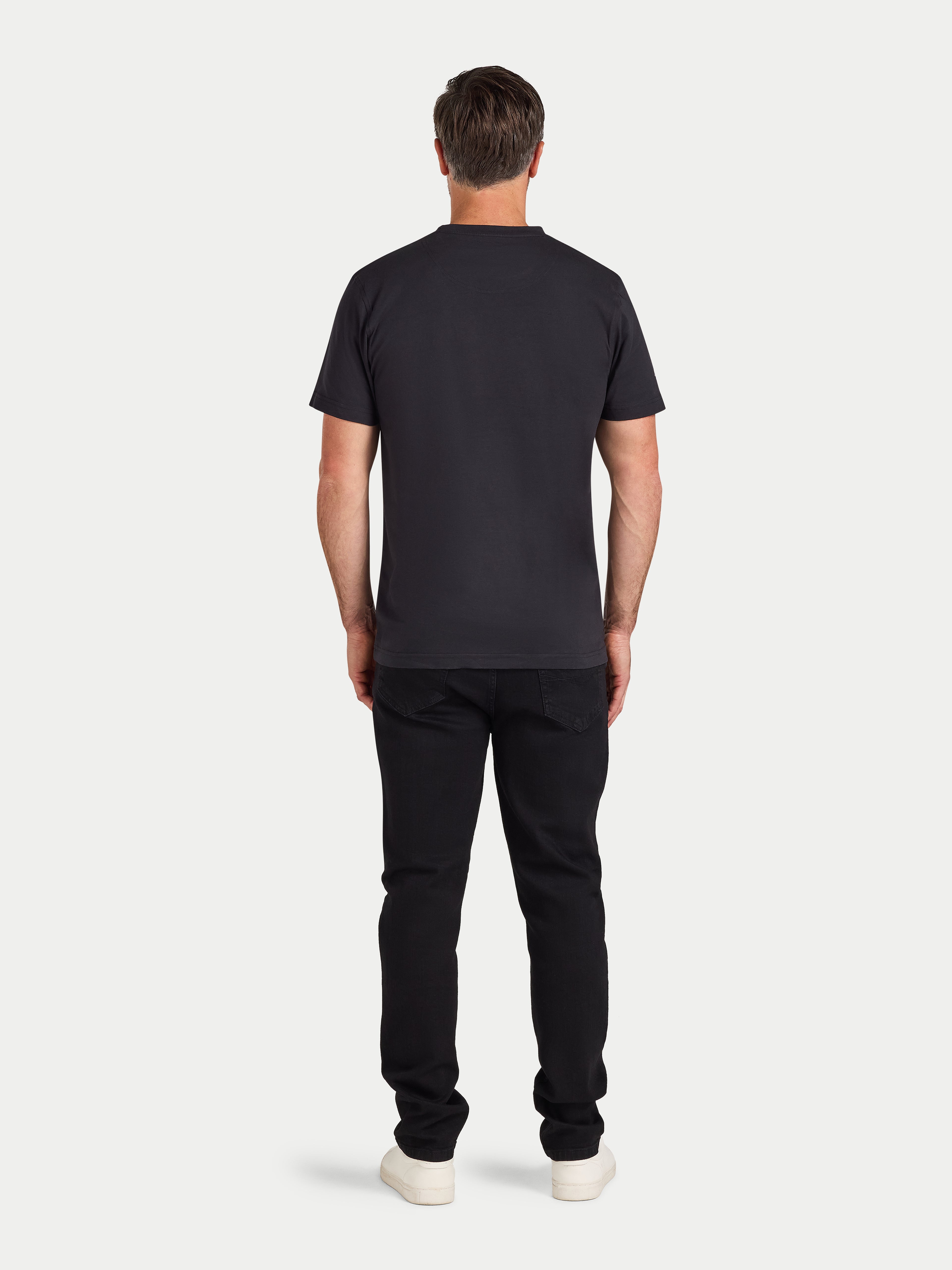 Man wearing a black t-shirt and pants on a white background