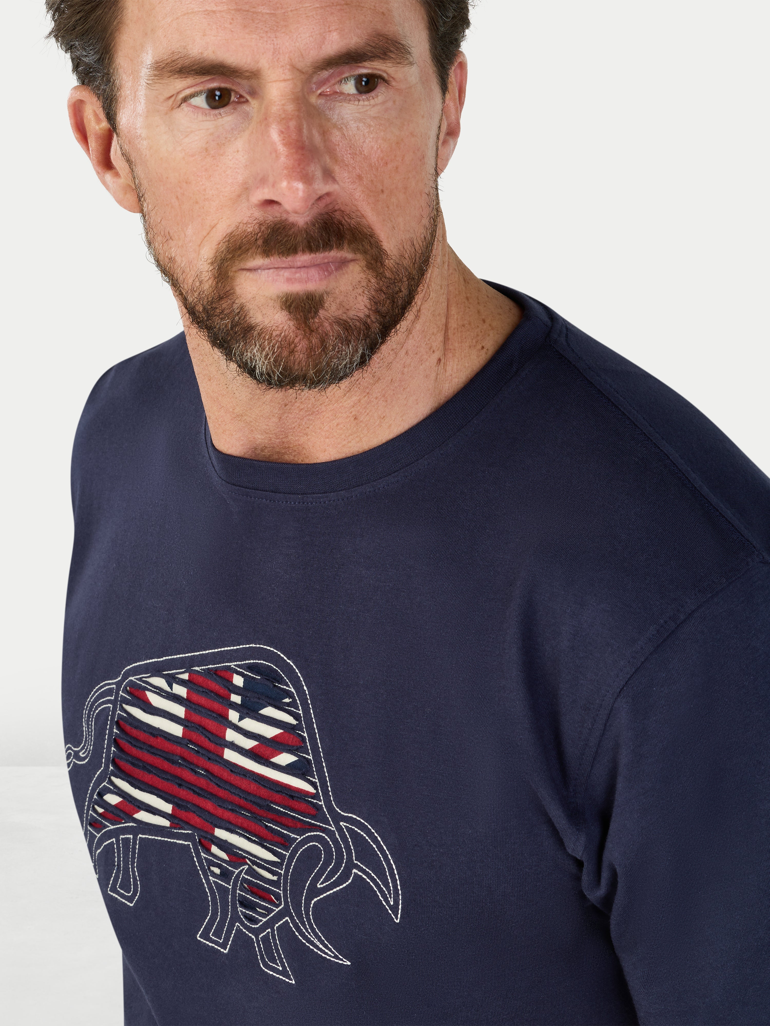 Man wearing a navy blue sweatshirt with a graphic design on a white background