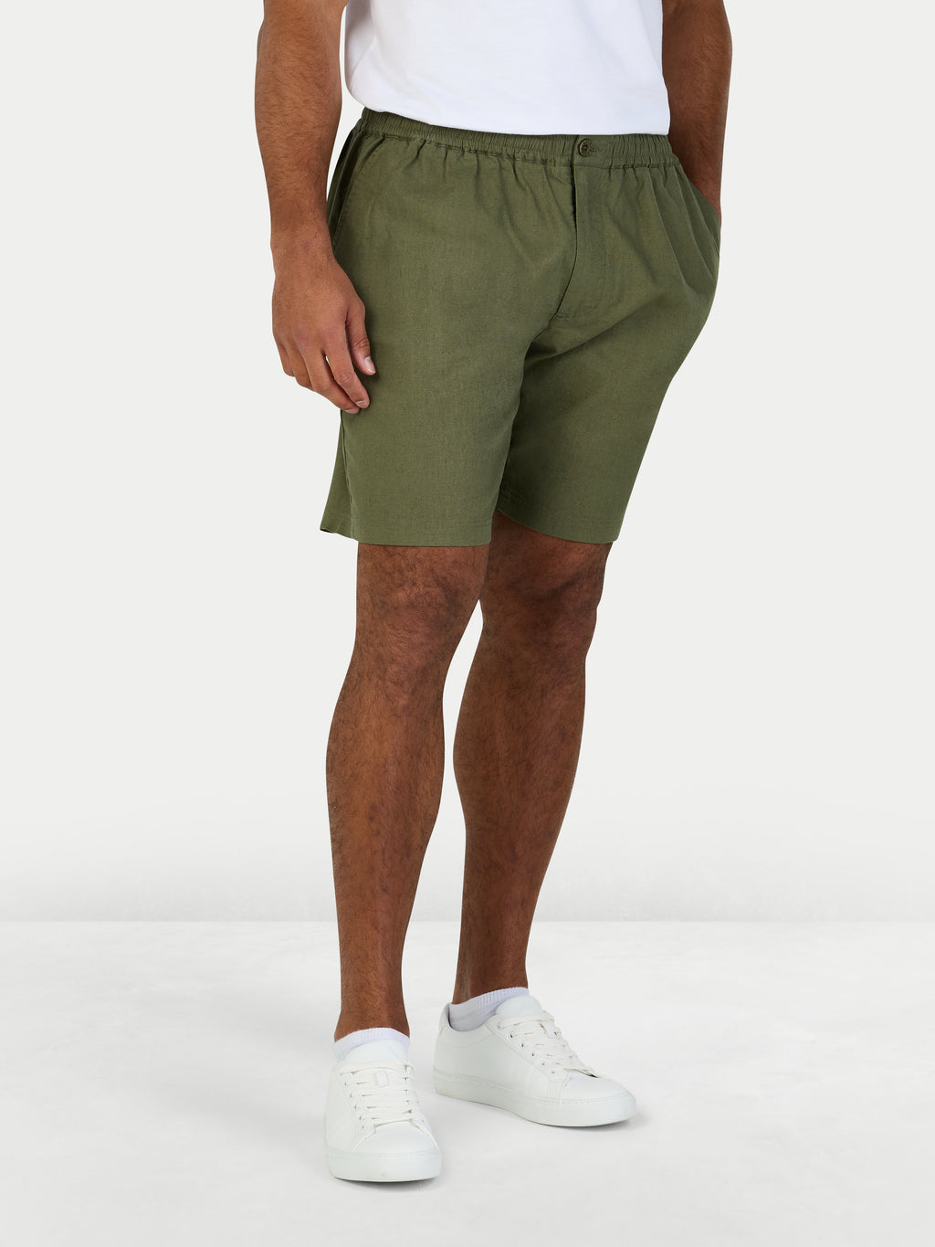 Person wearing olive green shorts on a white background