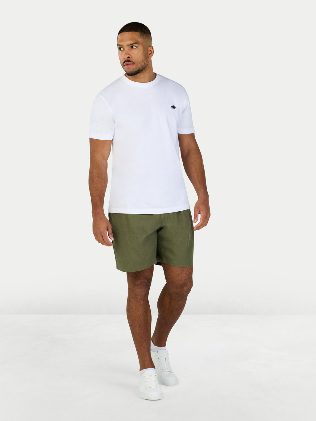Man wearing a white t-shirt and green shorts on a white background