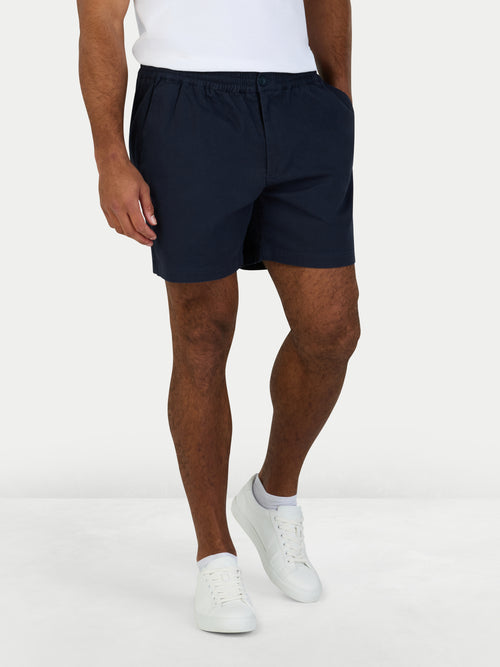 Man wearing stretch chino shorts in navy.