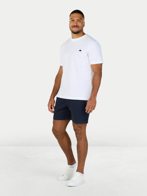 Man wearing a white t-shirt and navy shorts on a white background