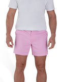 Man wearing a white t-shirt and stretch chino short in pink. 
