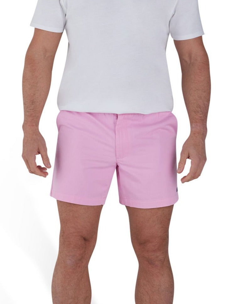 Man wearing a white t-shirt and stretch chino short in pink. 
