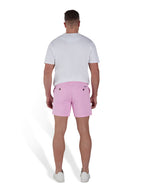 Man wearing pink shorts and a white t-shirt. 