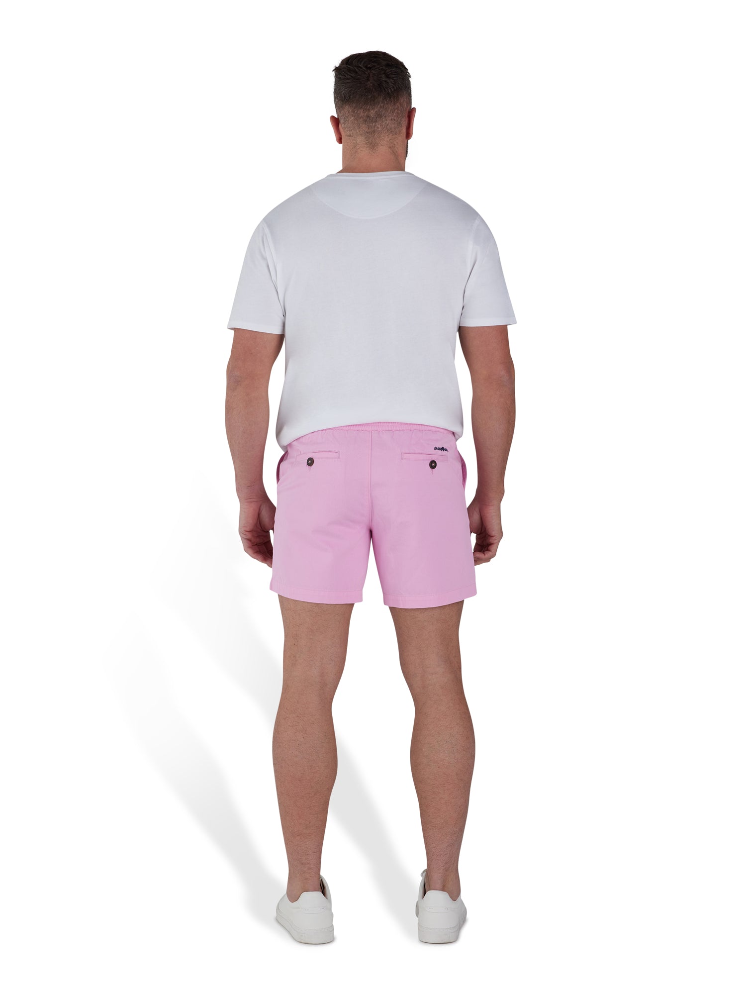 Man wearing pink shorts and a white t-shirt. 