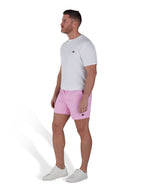 Man wearing pink shorts and a white t-shirt. 