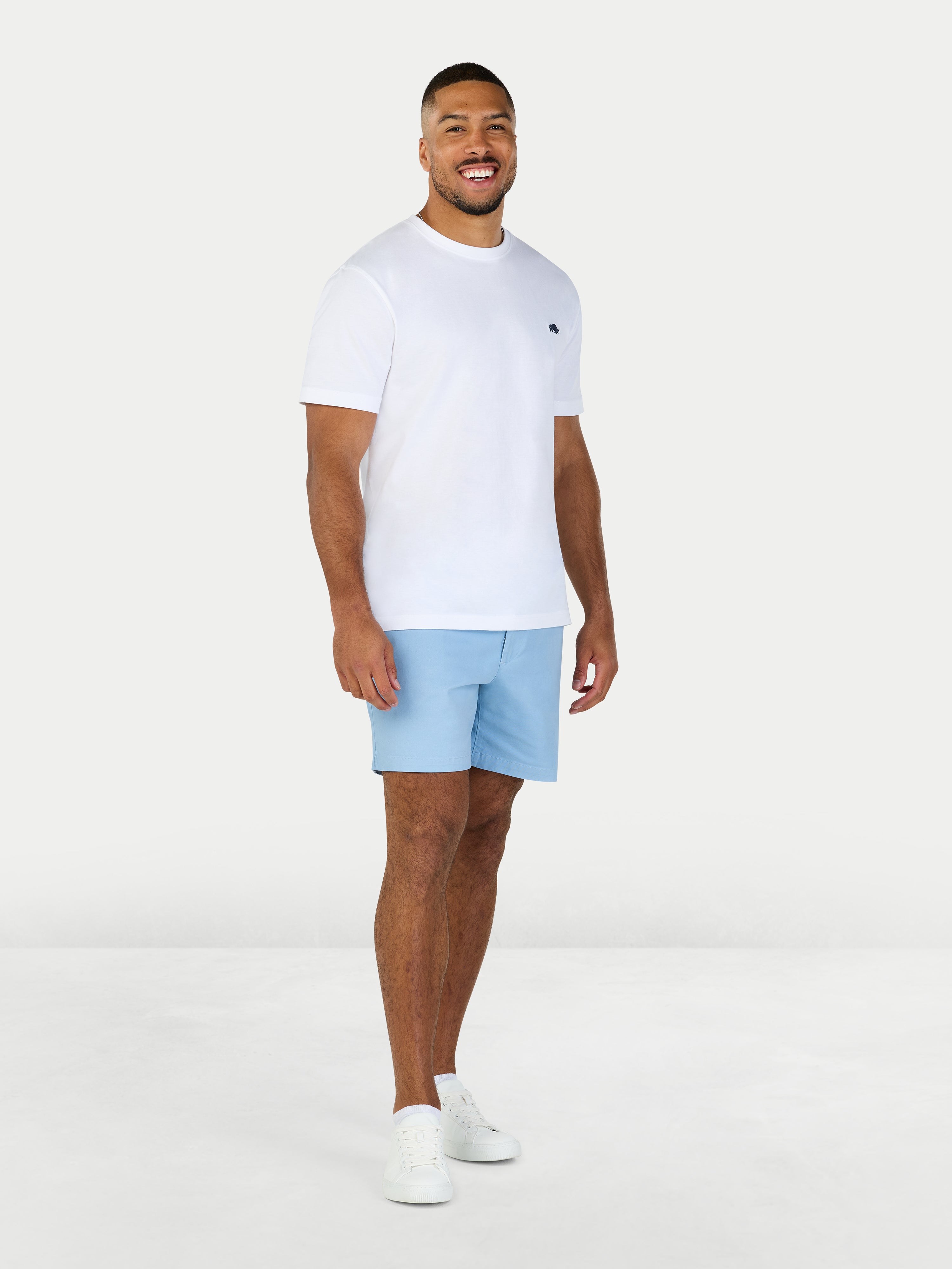 Man wearing a white t-shirt and light blue shorts on a white background