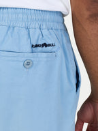 Light blue shorts with a brand logo on the pocket against a neutral background