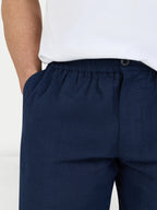 Navy blue pants worn by a person on a white background