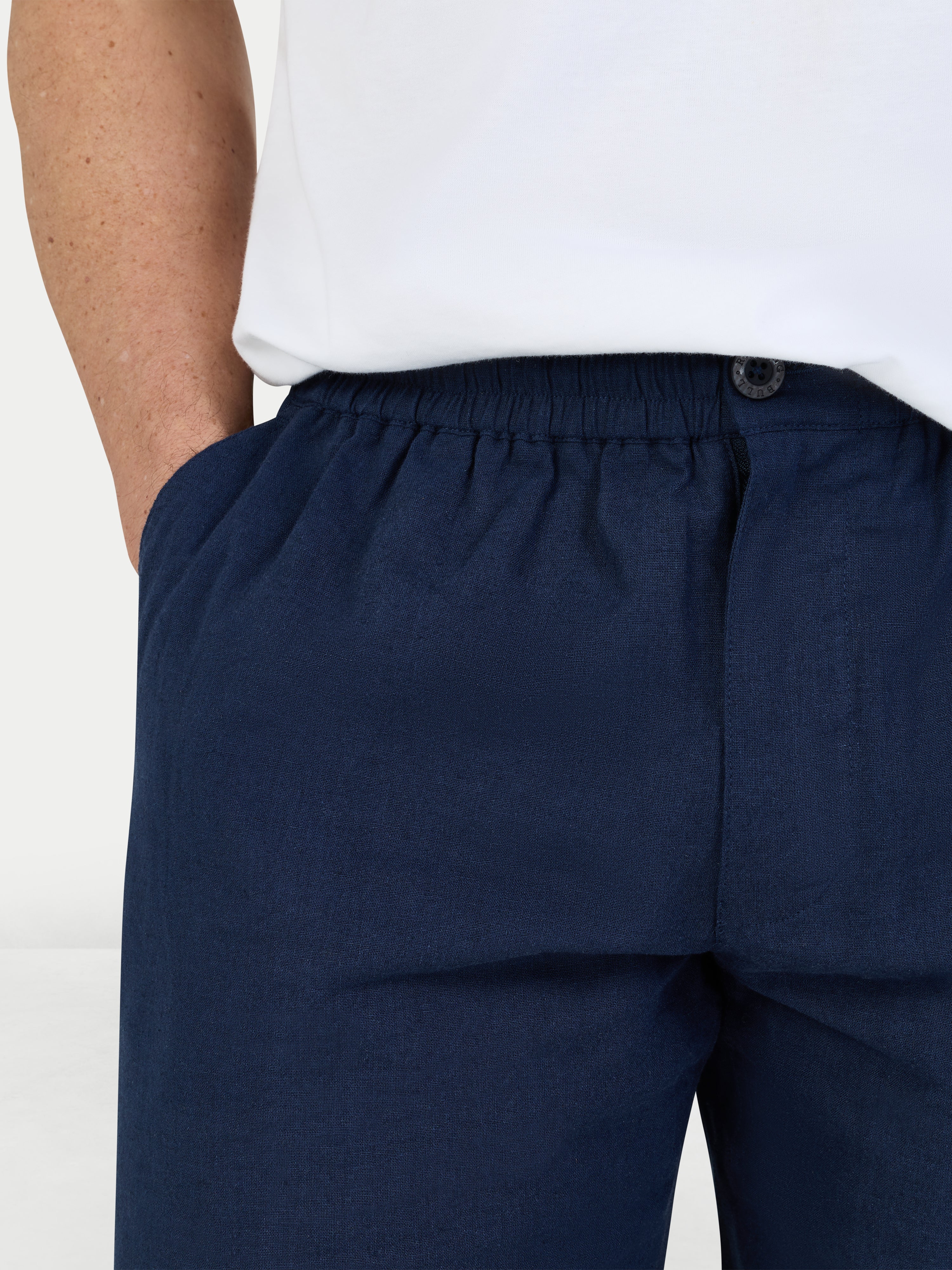 Navy blue pants worn by a person on a white background