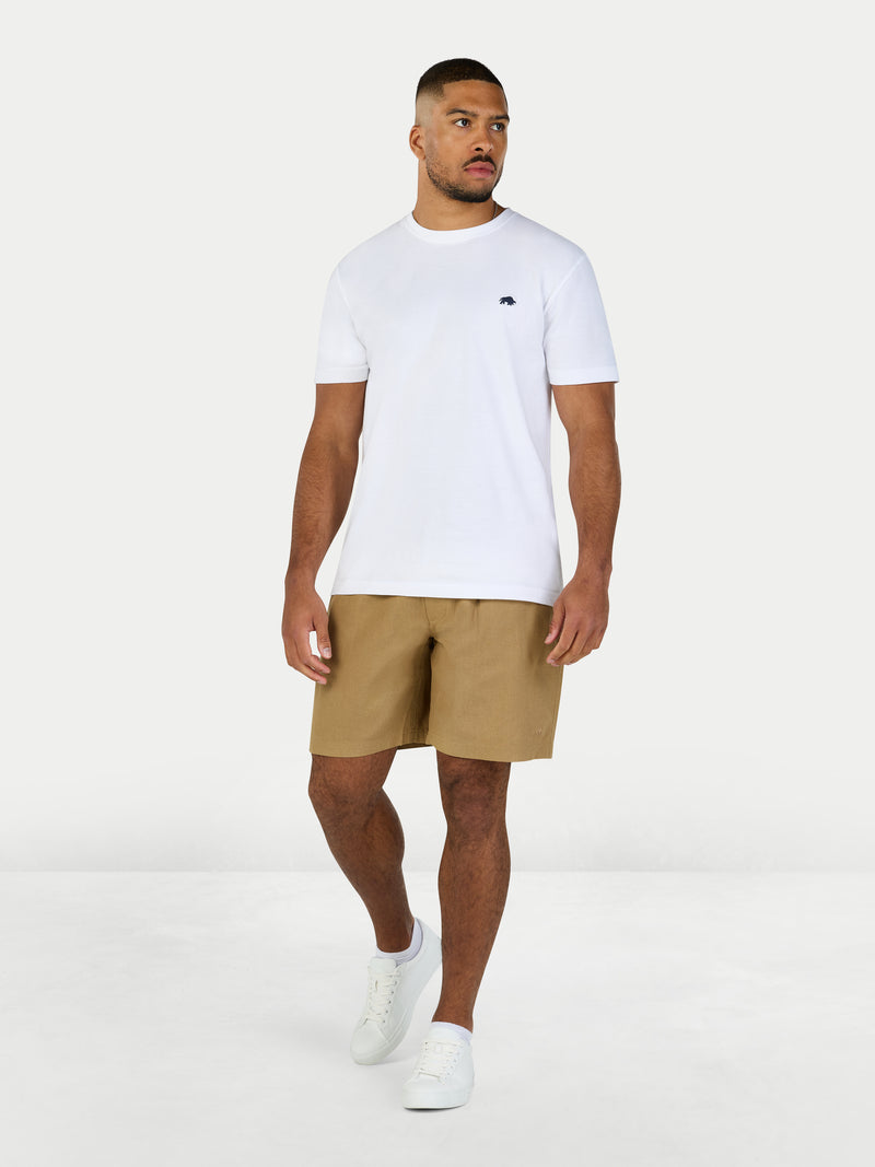 Man wearing a white t-shirt and beige shorts on a white background