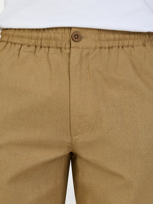 Close-up of sand coloured cargo shorts with a white shirt underneath