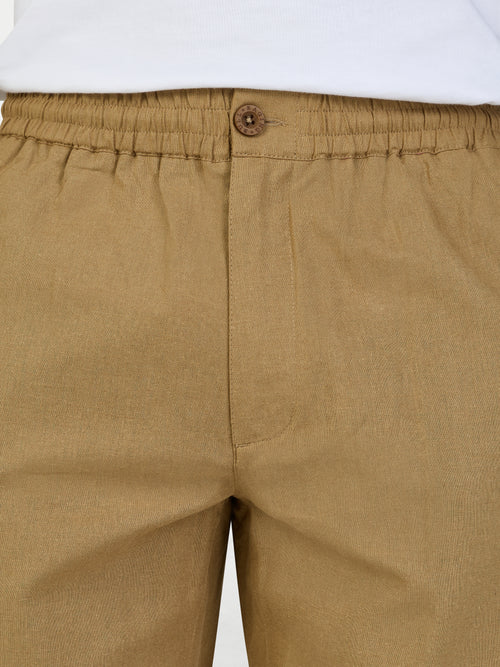 Close-up of sand coloured cargo shorts with a white shirt underneath