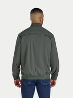 Man wearing a green jacket and blue jeans on a white background