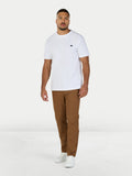 Man wearing a white t-shirt and brown pants on a white background