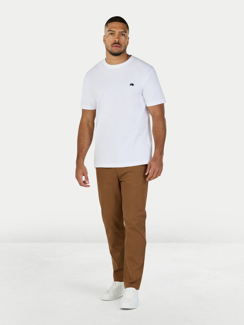 Man wearing a white t-shirt and brown pants on a white background