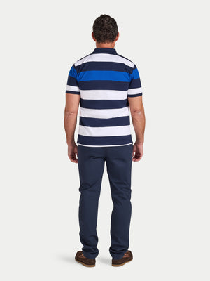 Man wearing a blue and white striped polo shirt and navy pants on a white background