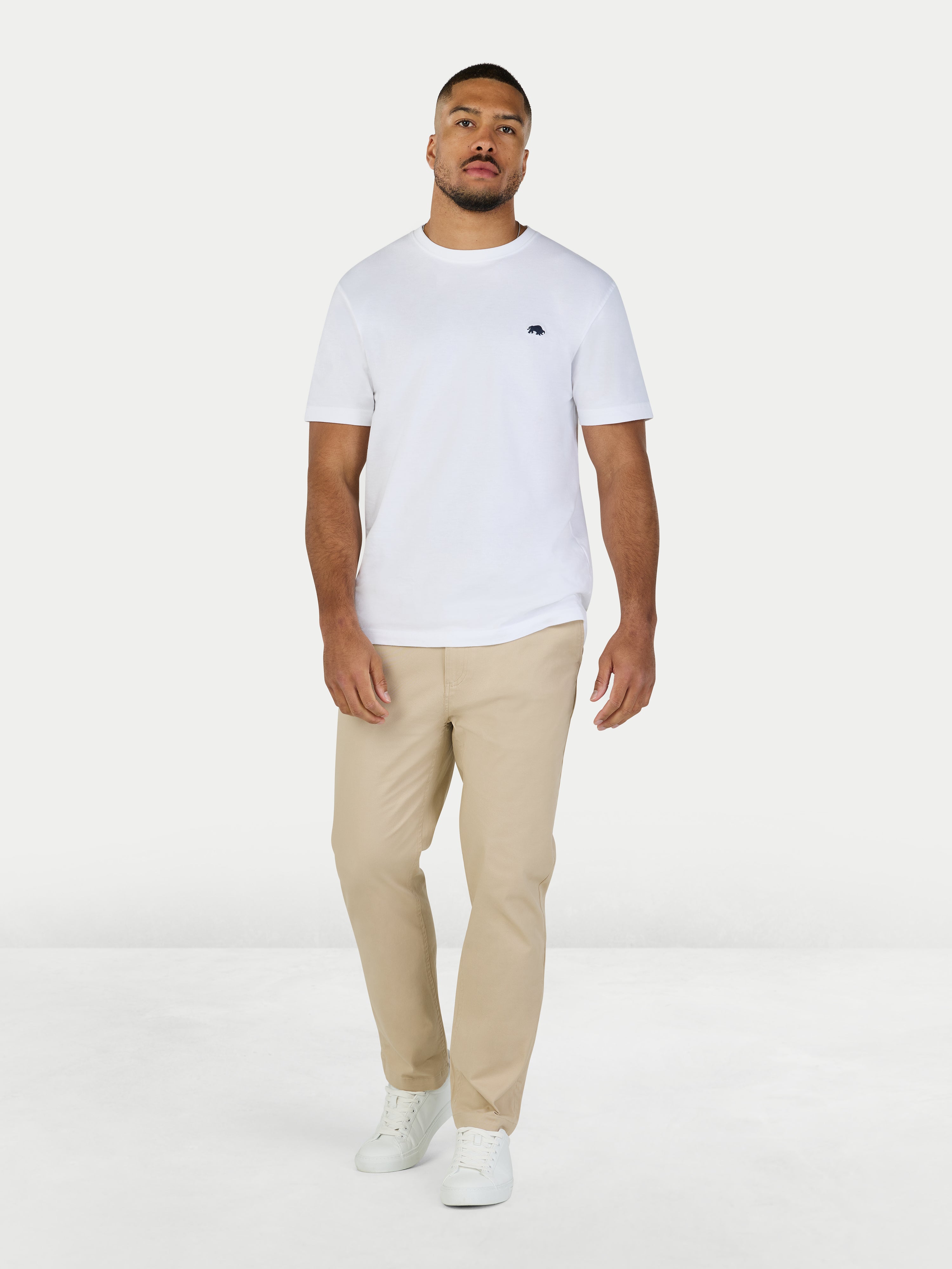 Man wearing a white t-shirt and beige pants on a white background