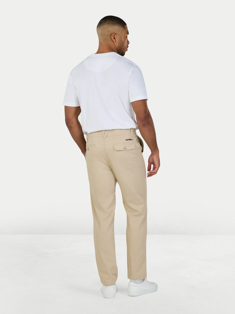 Man wearing a white t-shirt and beige pants on a white background