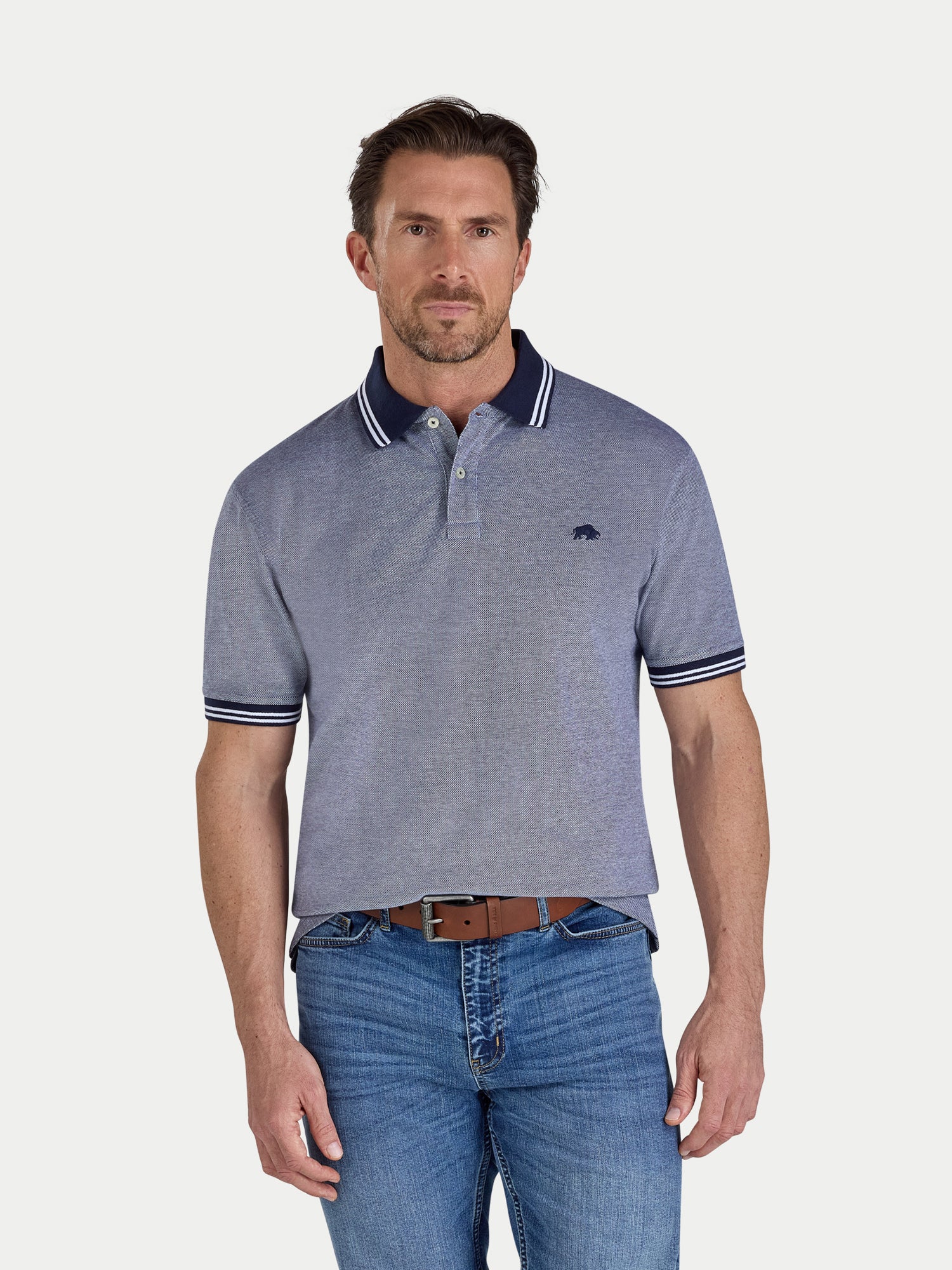 Man wearing a blue polo shirt with white stripes on a light gray background