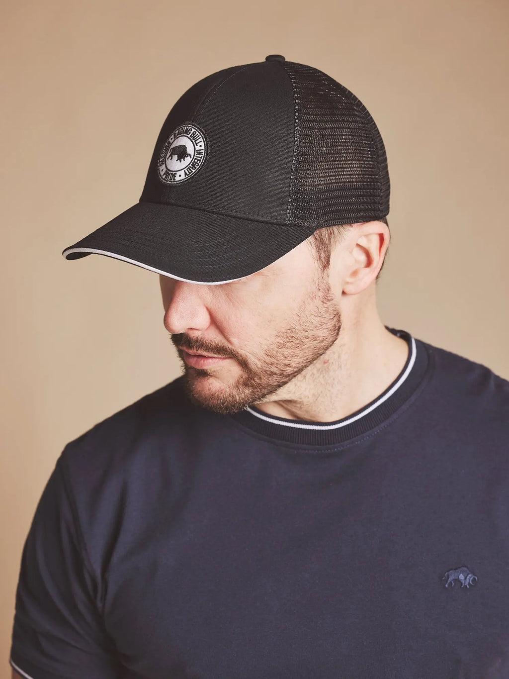Man wearing a Raging Bull Tri colour mesh back cap in black, side detail.