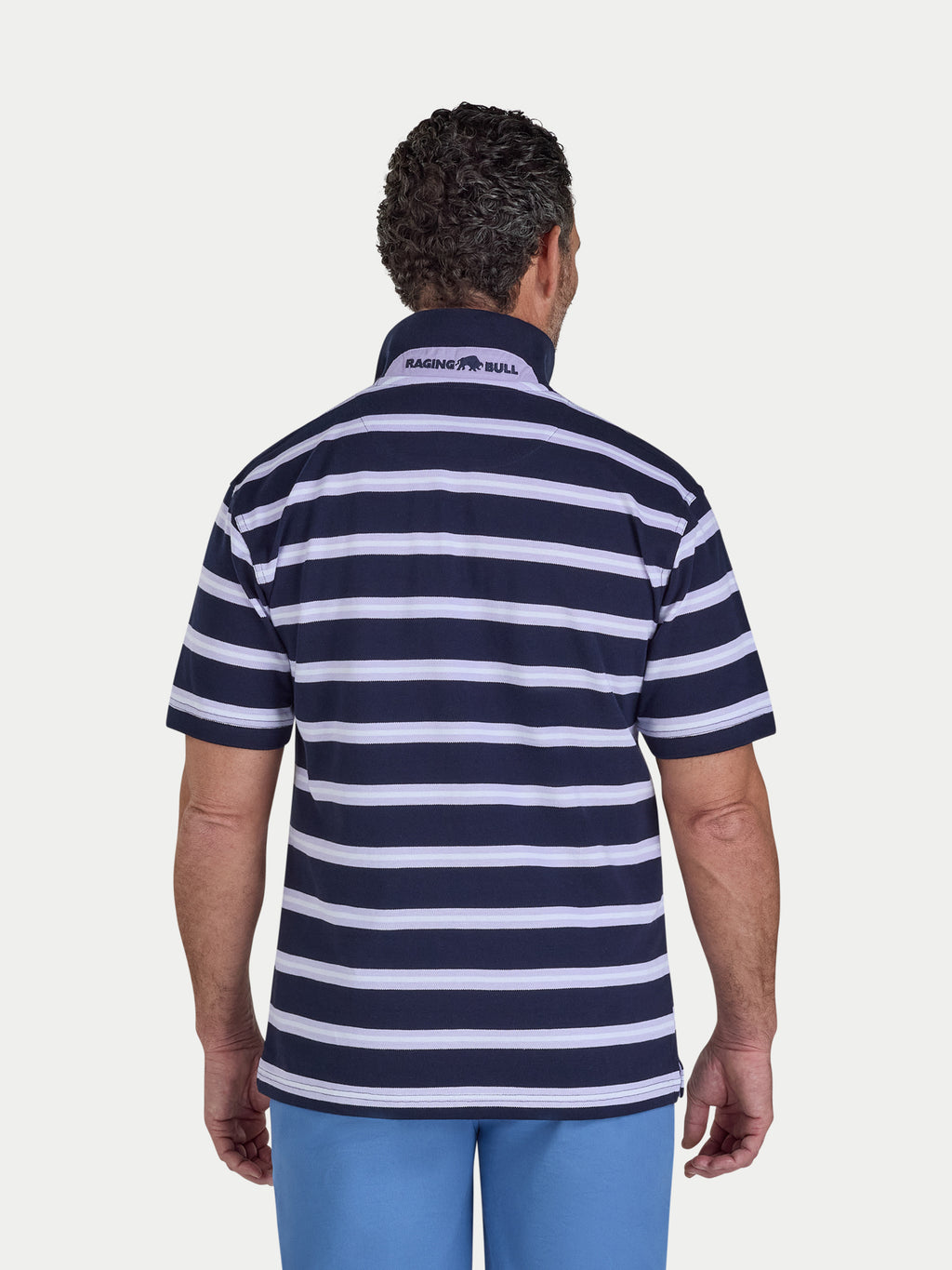 Man wearing a navy and white striped polo shirt with a visible brand logo on a light gray background
