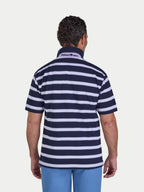 Man wearing a navy and white striped polo shirt with a visible brand logo on a light gray background