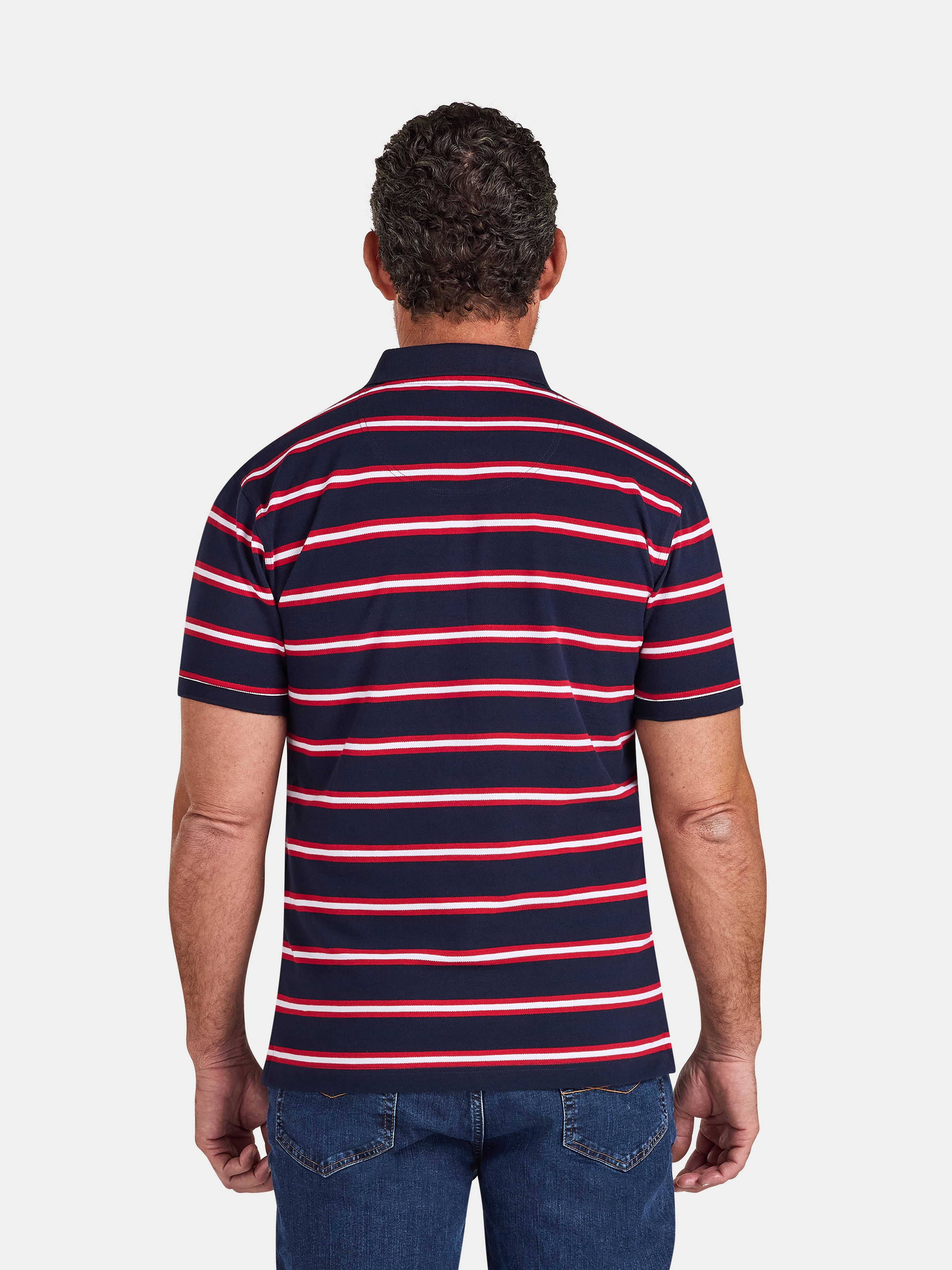 Man wearing a navy and red striped polo shirt on a white background