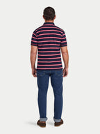 Man wearing a striped polo shirt and jeans on a white background