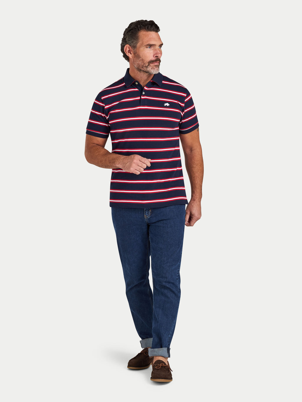 Man wearing a striped polo shirt and jeans on a white background