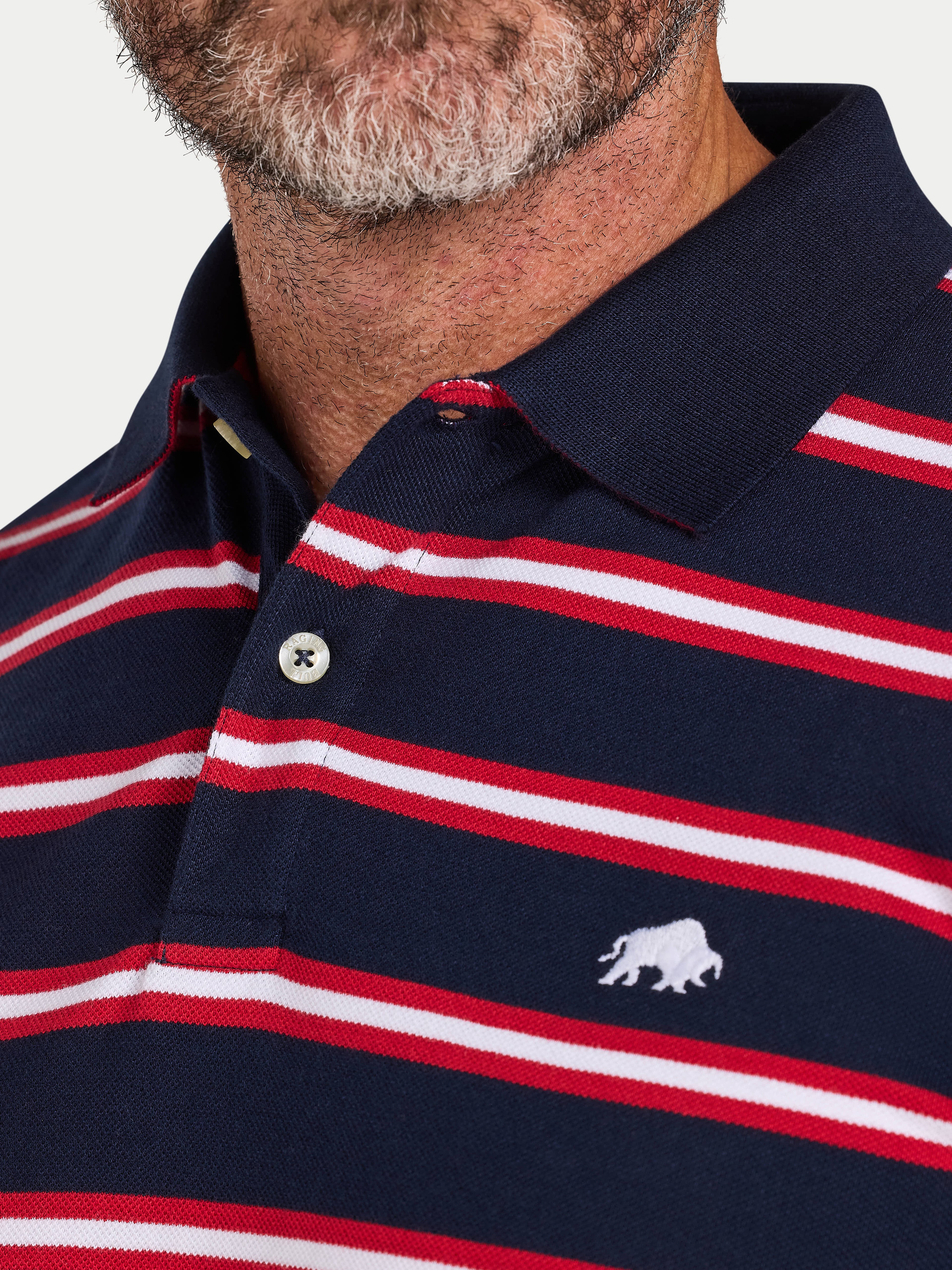 Navy, red, and white striped polo shirt with a logo on a plain background