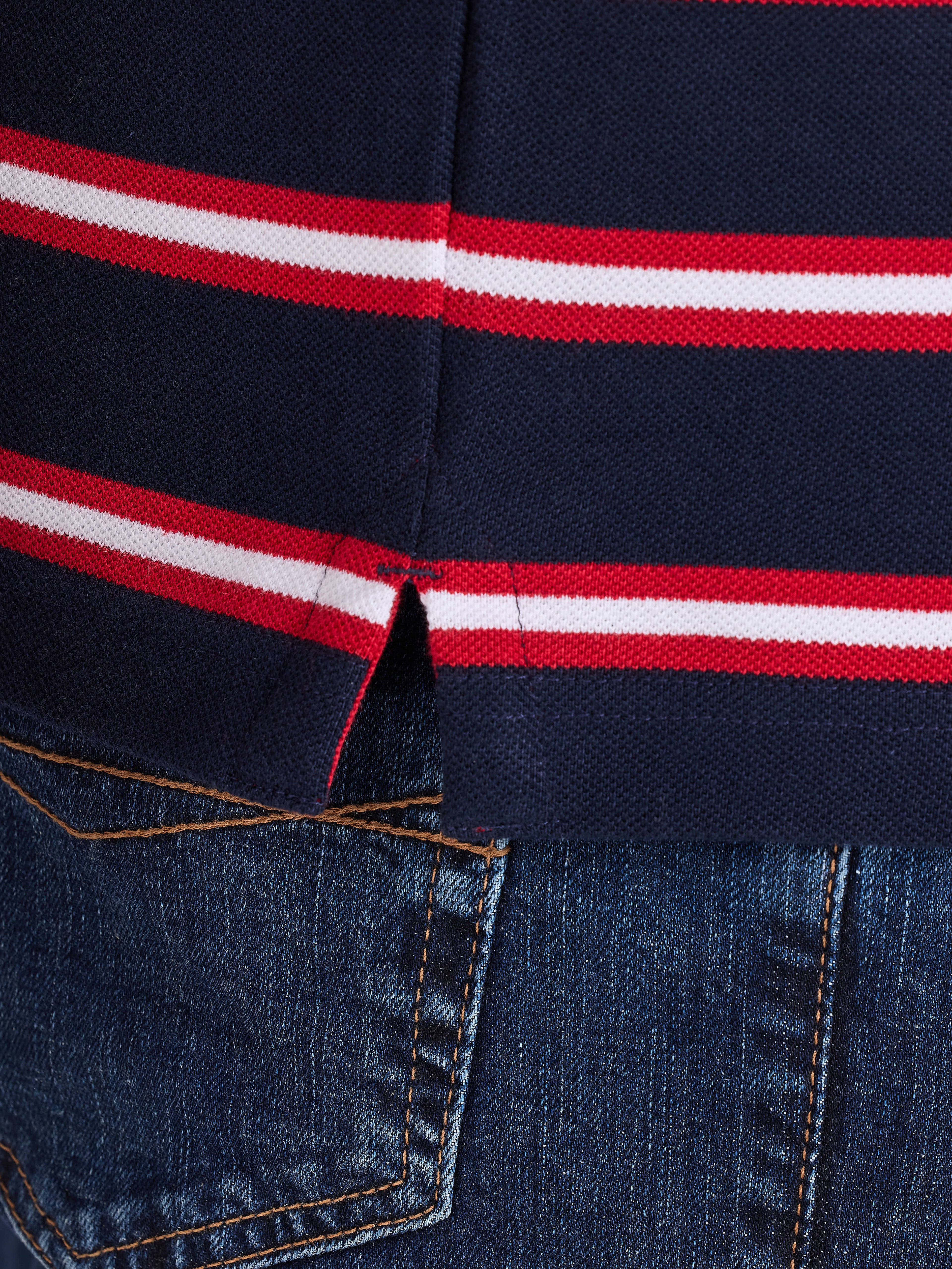 Close-up of a navy blue polo shirt with red and white stripes on the collar.