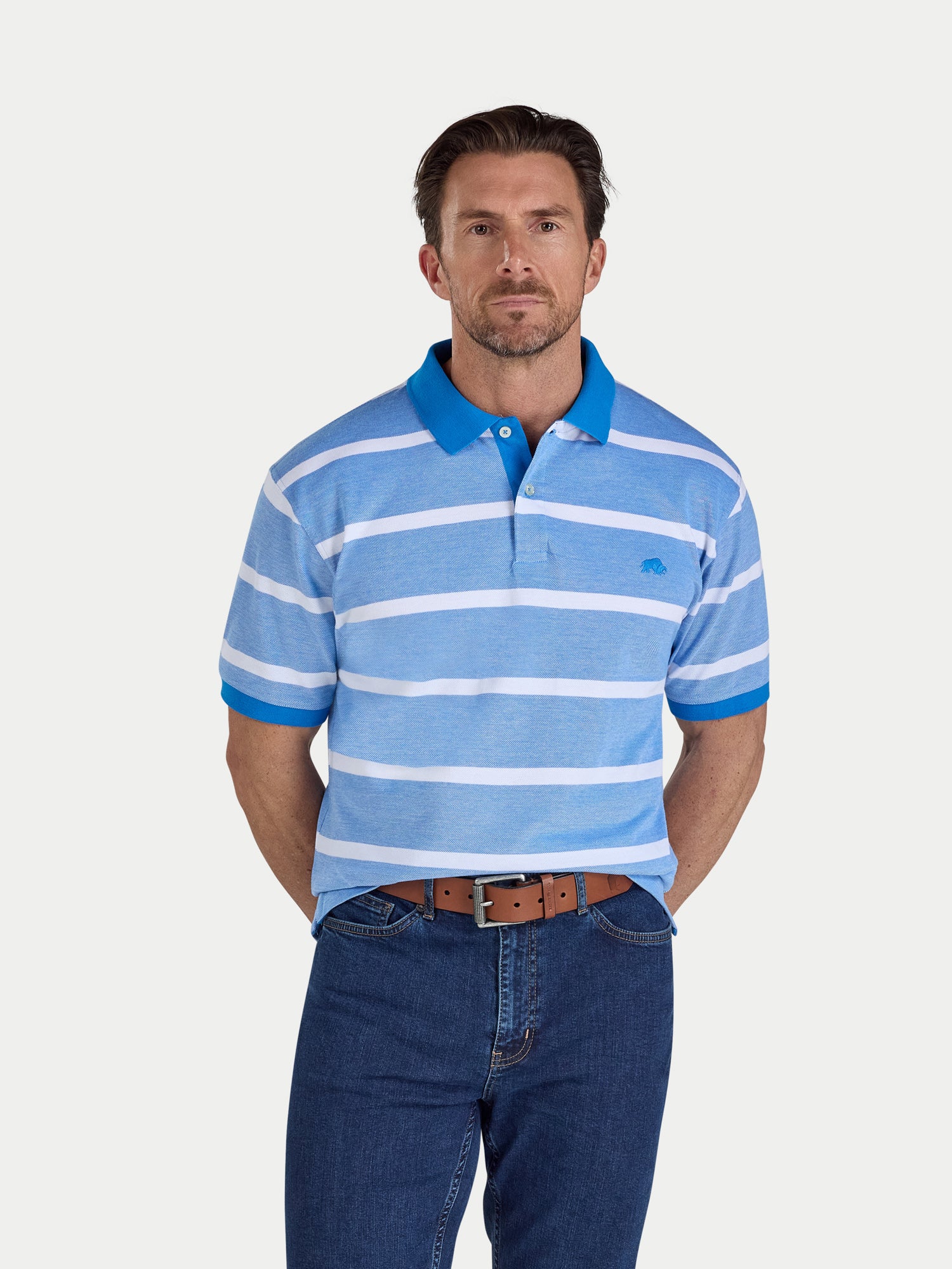 Man wearing a blue and white striped polo shirt with a plain background