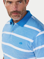 Man wearing a blue and white striped polo shirt with a small Raging Bull logo on a light gray background