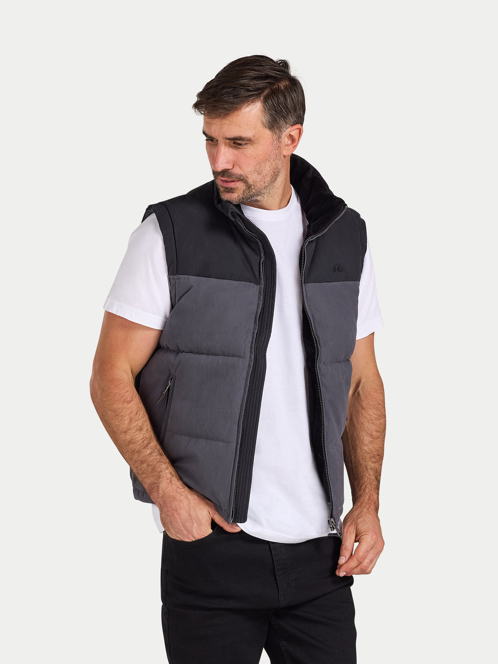 Man wearing a black and gray quilted vest on a white background