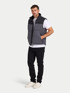 Man wearing a gray and black quilted vest on a white background
