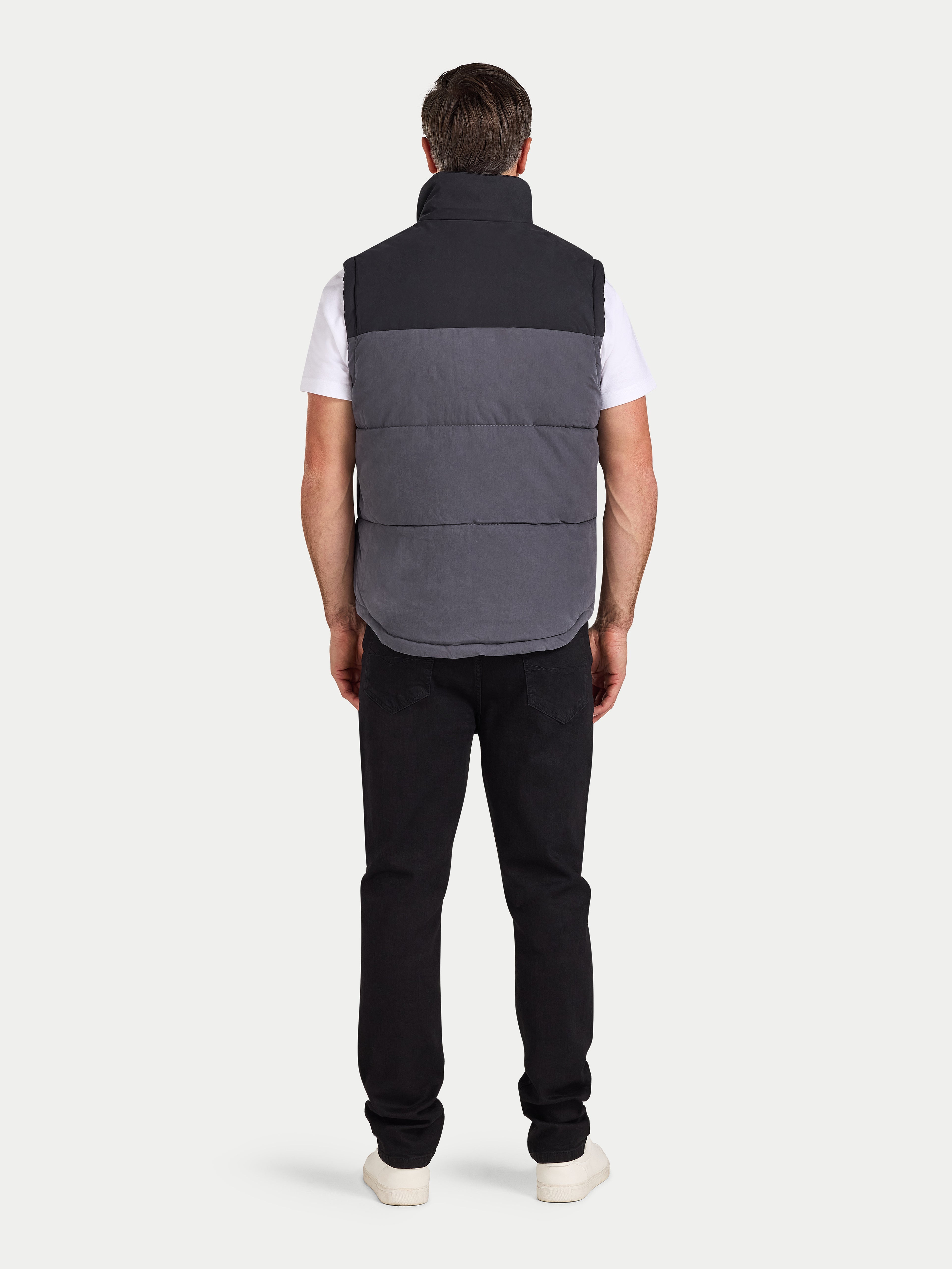 Person wearing a two-tone vest on a white background