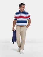 Man wearing a striped polo shirt and beige pants on a white background