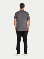 Man wearing a gray t-shirt and black pants on a white background