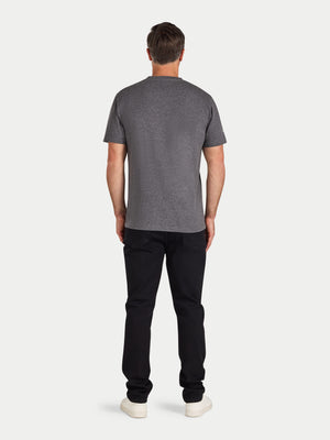 Man wearing a gray t-shirt and black pants on a white background