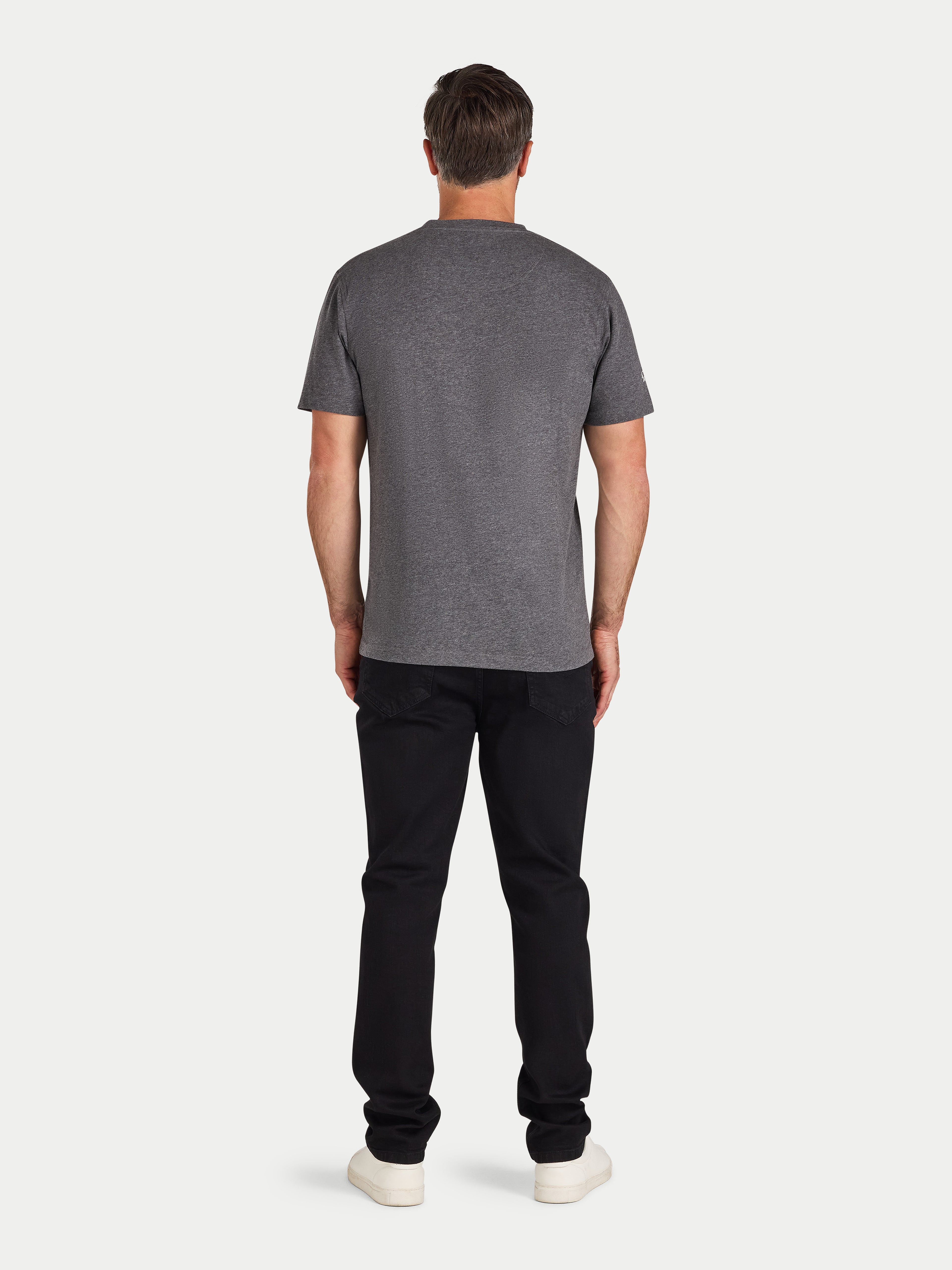 Man wearing a gray t-shirt and black pants on a white background